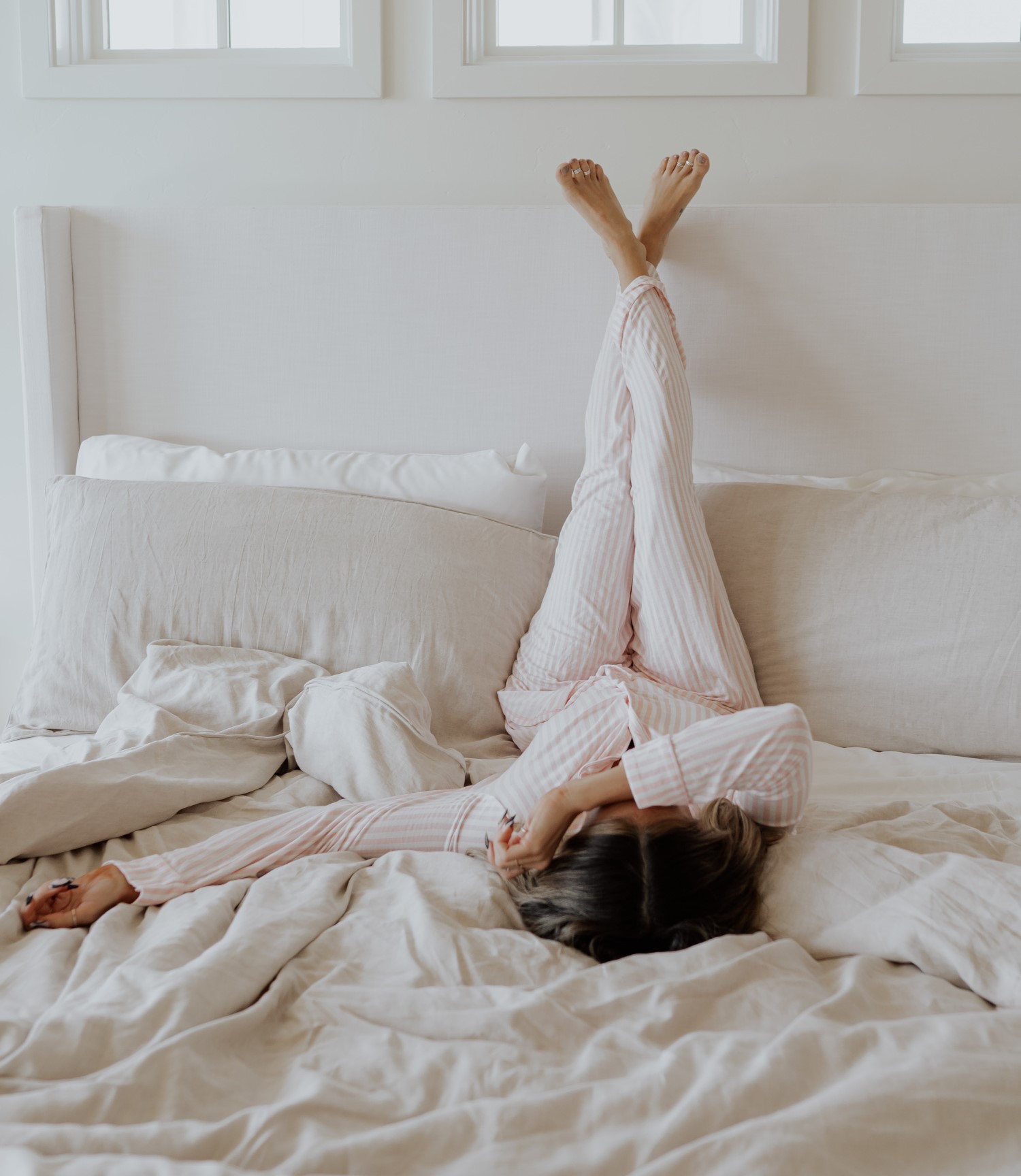 Bedroom scene image brief showing Cariloha Classic Bamboo Bed Sheet Set on a queen bed in a warm-climate bedroom with fan airflow and thin duvet layer